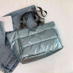 Bolsa de Academia Feminina Grande para Yoga com Compartimento para Mat Azul Urbanno, estilo tote acolchoada, disposta sobre uma jaqueta jeans clara, destacando sua cor e textura brilhante.