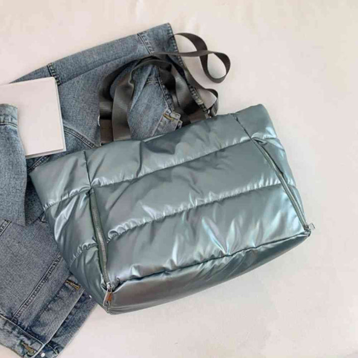 Bolsa de Academia Feminina Grande para Yoga com Compartimento para Mat Azul Urbanno, estilo tote acolchoada, disposta sobre uma jaqueta jeans clara, destacando sua cor e textura brilhante.