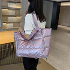 Mulher usando a Bolsa de Academia Feminina Grande para Yoga com Compartimento para Mat Lilás Urbanno no ombro, demonstrando seu tamanho e estilo elegante em um ambiente interno.