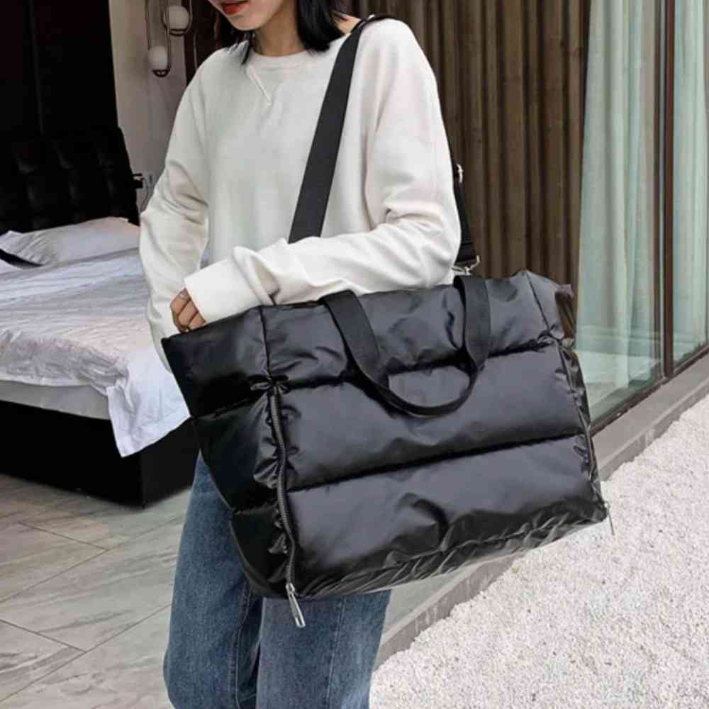 Mulher usando uma Bolsa de Academia Feminina Grande para Yoga com Compartimento para Mat Preta Urbanno no ombro, com alça transversal, em ambiente urbano, demonstrando seu tamanho e estilo.