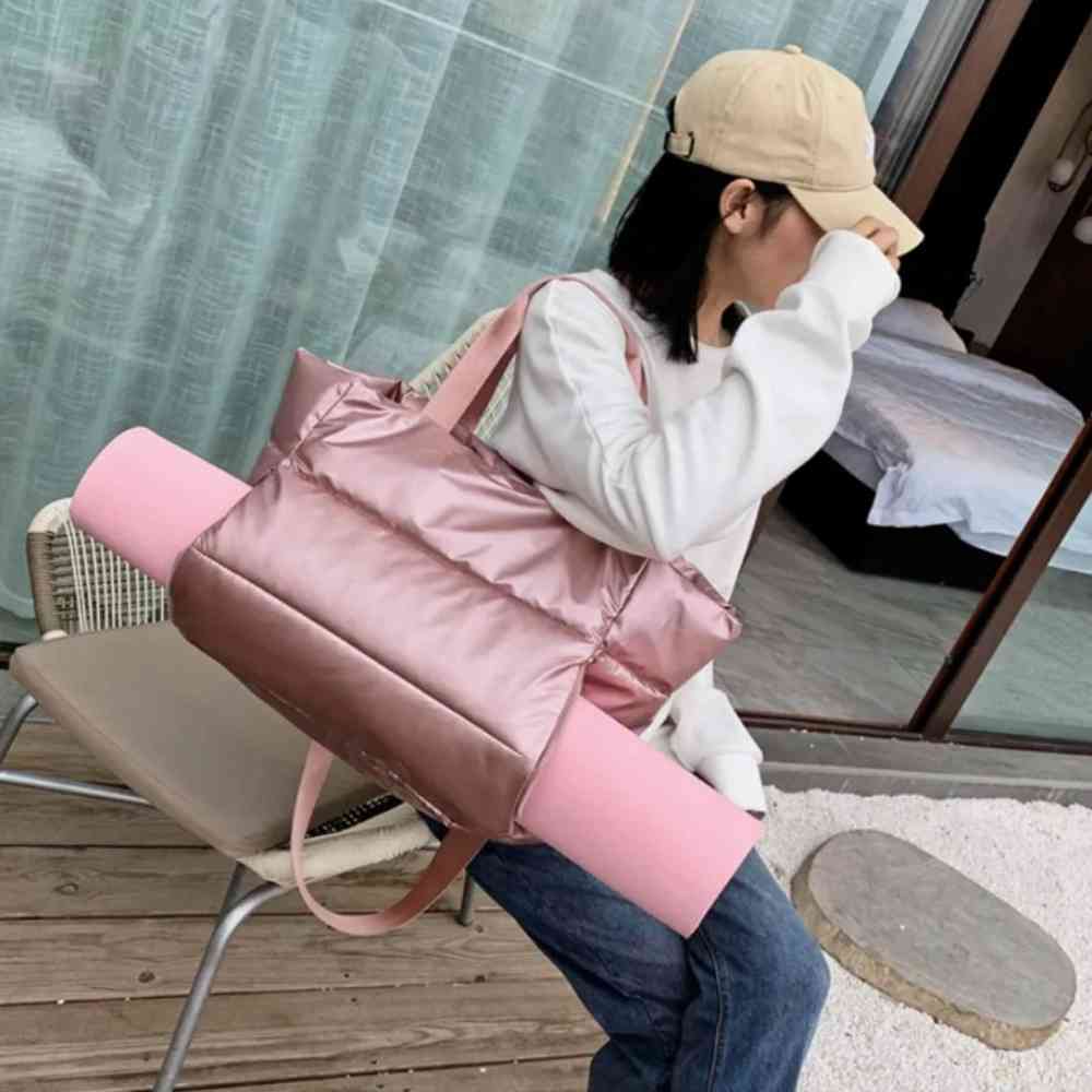 Mulher usando a Bolsa de Academia Feminina Grande para Yoga com Compartimento para Mat Rosa Urbanno, carregando um tapete de yoga rosa preso lateralmente, demonstrando a funcionalidade do compartimento.