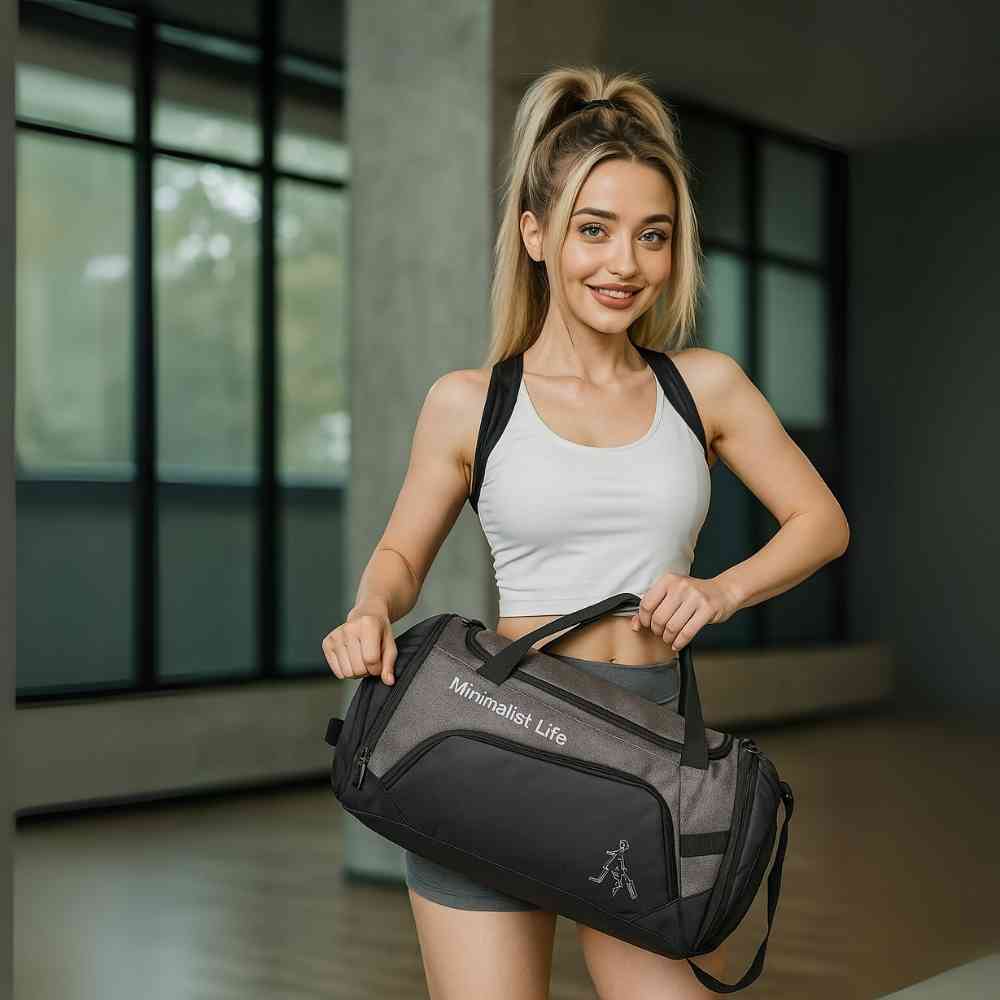 mulher carregando a Bolsa de Academia Grande com Compartimento de Sapatos Cinza Grafite Urbanno pela alça, subindo escadas, demonstrando a praticidade de transporte no dia a dia.