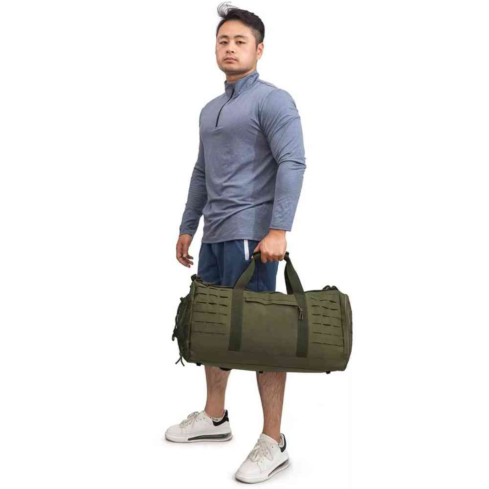 Homem com roupa de treino carregando a Bolsa de Academia Tática 40L Impermeável Verde Militar Urbanno pelas alças de mão, demonstrando o tamanho e a facilidade de transporte.