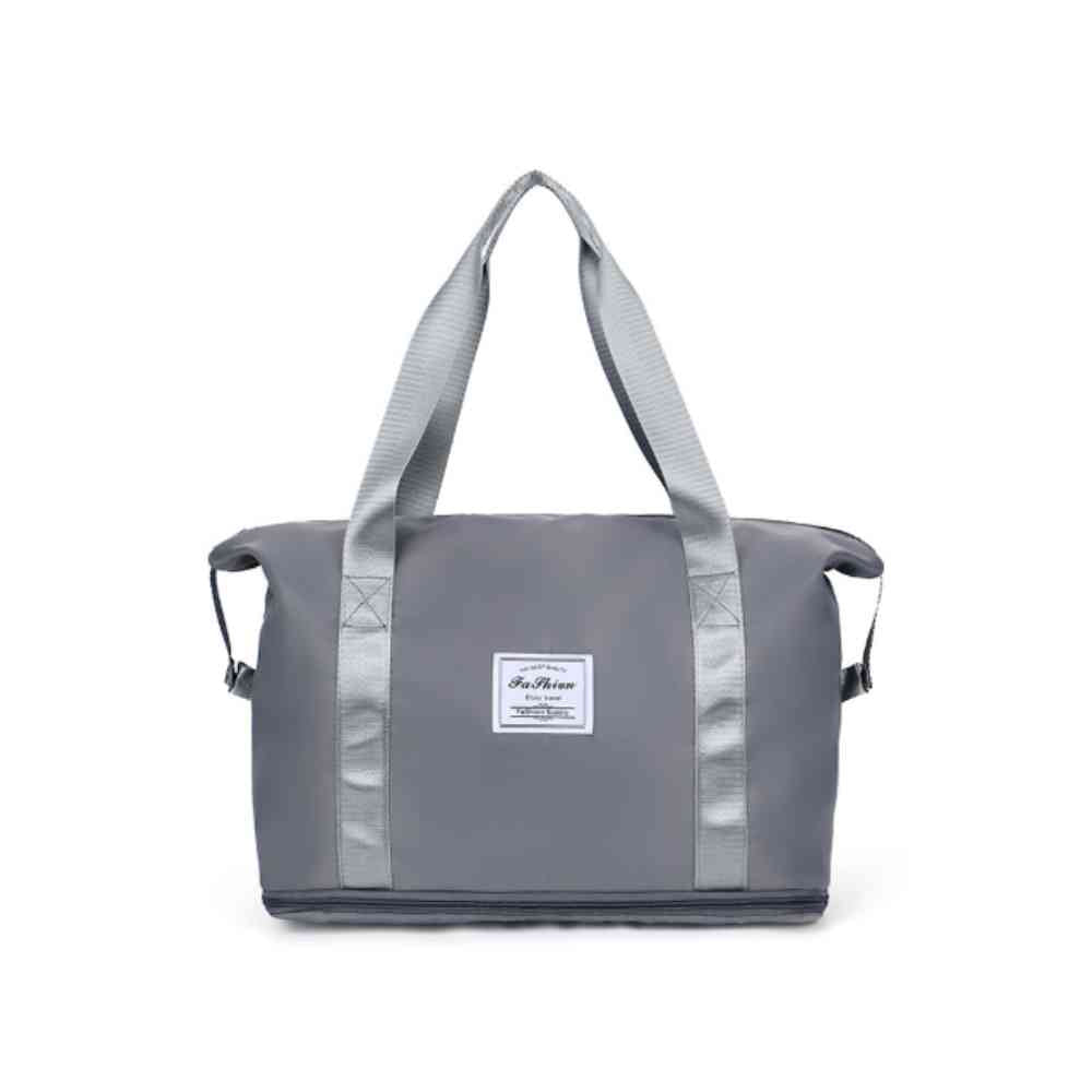 Bolsa de Academia e Viagem Feminina Leve Expansível Cinza Urbanno, vista frontal em seu estado compacto, com alças duplas e etiqueta da marca, pronta para ser expandida e usada.