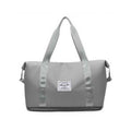 Bolsa de Academia e Viagem Feminina Leve Expansível Cinza Urbanno, vista frontal, com design espaçoso e etiqueta da marca na frente, ideal para praticidade no dia a dia e viagens.