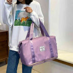 Pessoa carregando a Bolsa de Academia e Viagem Feminina Leve Expansível Lilás Urbanno pelas alças de mão, demonstrando seu tamanho e a facilidade de transporte no dia a dia.