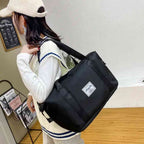 Mulher usando a Bolsa de Academia e Viagem Feminina Leve Expansível Preta Urbanno no ombro, demonstrando seu tamanho e praticidade para diversas atividades.