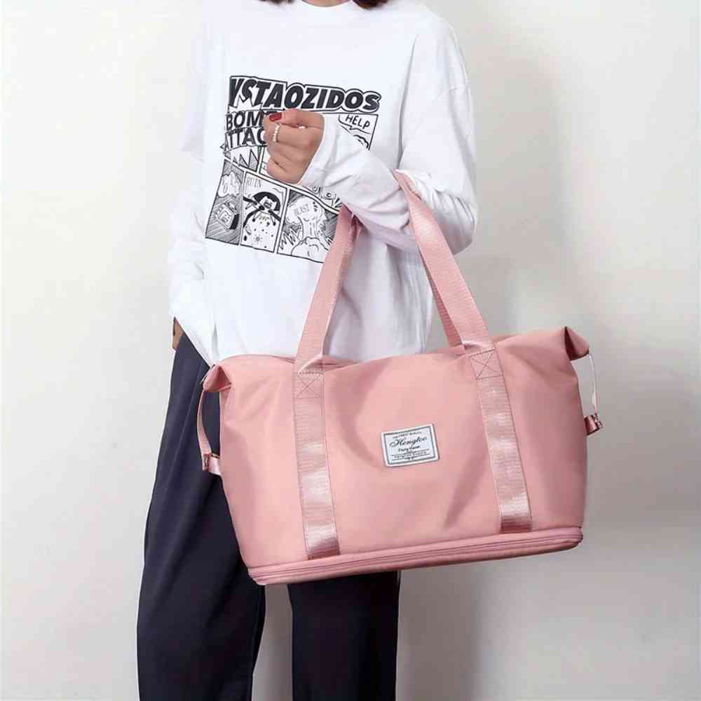 Pessoa carregando a Bolsa de Academia e Viagem Feminina Leve Expansível Rosa Urbanno pelas alças de mão, demonstrando seu tamanho e a facilidade de transporte no dia a dia.