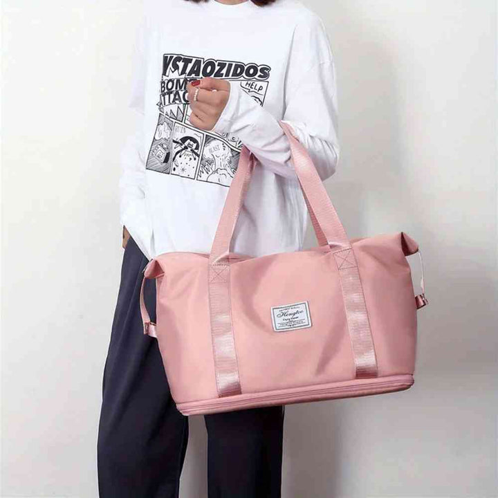 Pessoa carregando a Bolsa de Academia e Viagem Feminina Leve Expansível Rosa Urbanno pelas alças de mão, demonstrando seu tamanho e a facilidade de transporte no dia a dia.