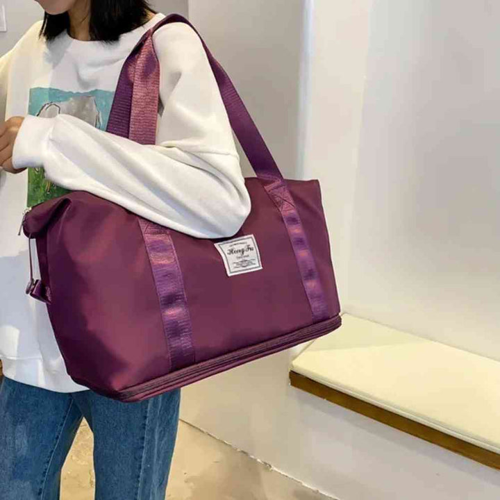 Mulher usando a Bolsa de Academia e Viagem Feminina Leve Expansível Vinho Urbanno no ombro, demonstrando seu tamanho e a elegância da cor em um ambiente interno.