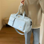 Bolsa de Academia e Viagem Feminina Multifuncional Azul Bebê Urbanno, sendo carregada no ombro por uma pessoa de moletom, demonstrando o tamanho e praticidade para uso diário ou viagens.