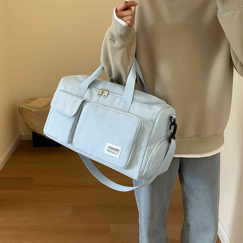 Bolsa de Academia e Viagem Feminina Multifuncional Azul Bebê Urbanno, sendo carregada no ombro por uma pessoa de moletom, demonstrando o tamanho e praticidade para uso diário ou viagens.