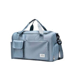 Bolsa de Academia e Viagem Feminina Multifuncional Azul Bebê Urbanno, vista lateral, com alça de ombro ajustável e zíperes, destacando o design compacto e os bolsos externos.