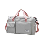 Bolsa de Academia e Viagem Feminina Multifuncional Cinza com Alça Rosa Urbanno, vista frontal, com múltiplos bolsos externos e alças cor de rosa, destacando seu design prático e elegante.