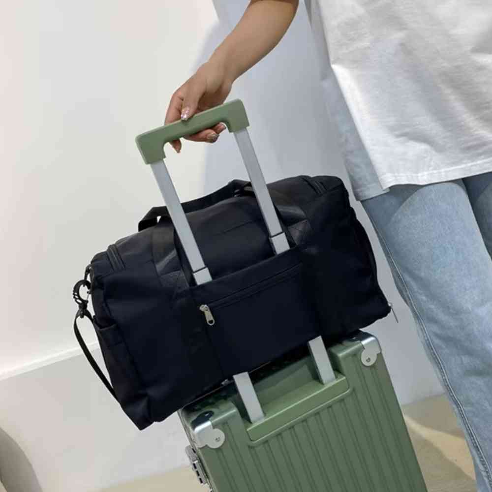 Bolsa de Academia e Viagem Feminina Multifuncional Preta Urbanno, acoplada à alça retrátil de uma mala de viagem verde, sendo transportada por uma pessoa, demonstrando sua praticidade para viagens.