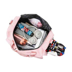 Bolsa de Academia e Viagem Feminina Multifuncional Rosa Pêssego Urbanno, vista interna com fones de ouvido, guarda-chuva, garrafa e outros itens, e um par de tênis no compartimento lateral, exibindo sua capacidade e organização.