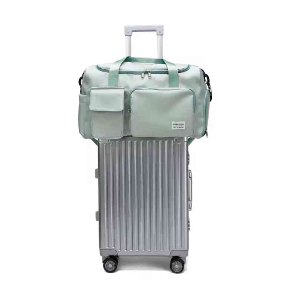 Bolsa de Academia e Viagem Feminina Multifuncional Verde Urbanno, acoplada à alça retrátil de uma mala de viagem prateada, demonstrando sua praticidade para viagens.