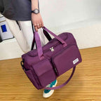 Bolsa de Academia e Viagem Feminina Multifuncional Vinho Urbanno, sendo carregada na mão por uma pessoa com calça clara, demonstrando o tamanho e praticidade para uso diário ou viagens.