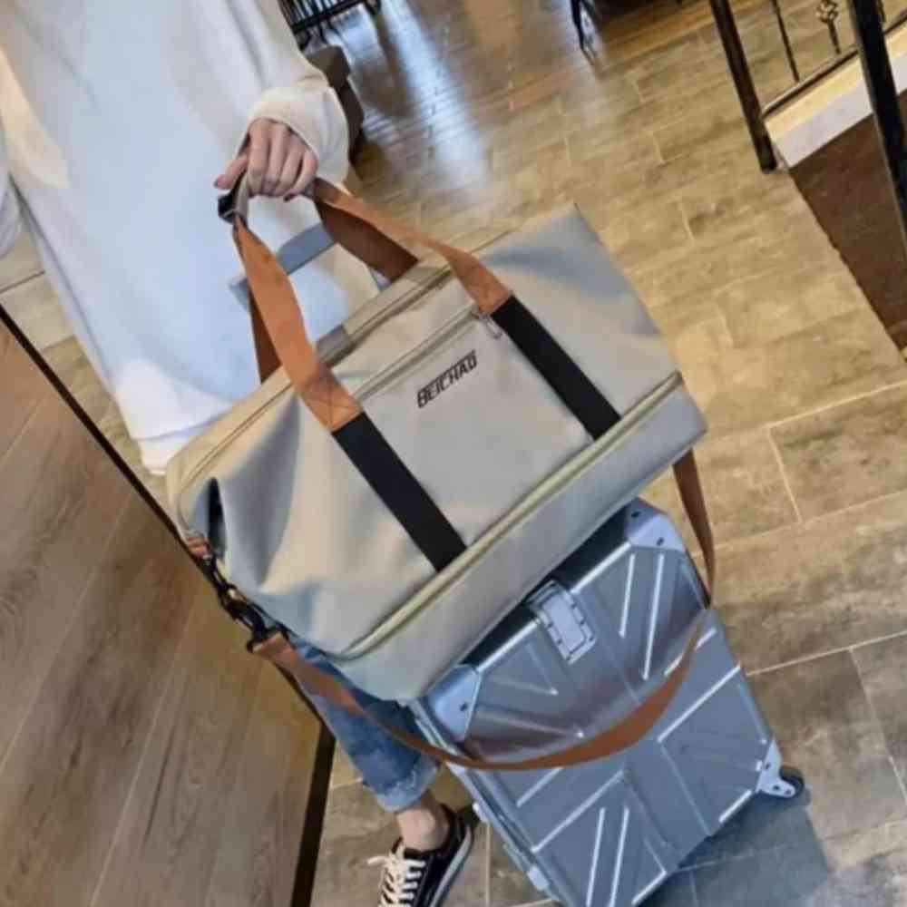 Bolsa de Academia e Viagem Grande com Compartimento de Sapatos Khaki Urbanno, acoplada à alça retrátil de uma mala de viagem, demonstrando sua praticidade para transporte em viagens.