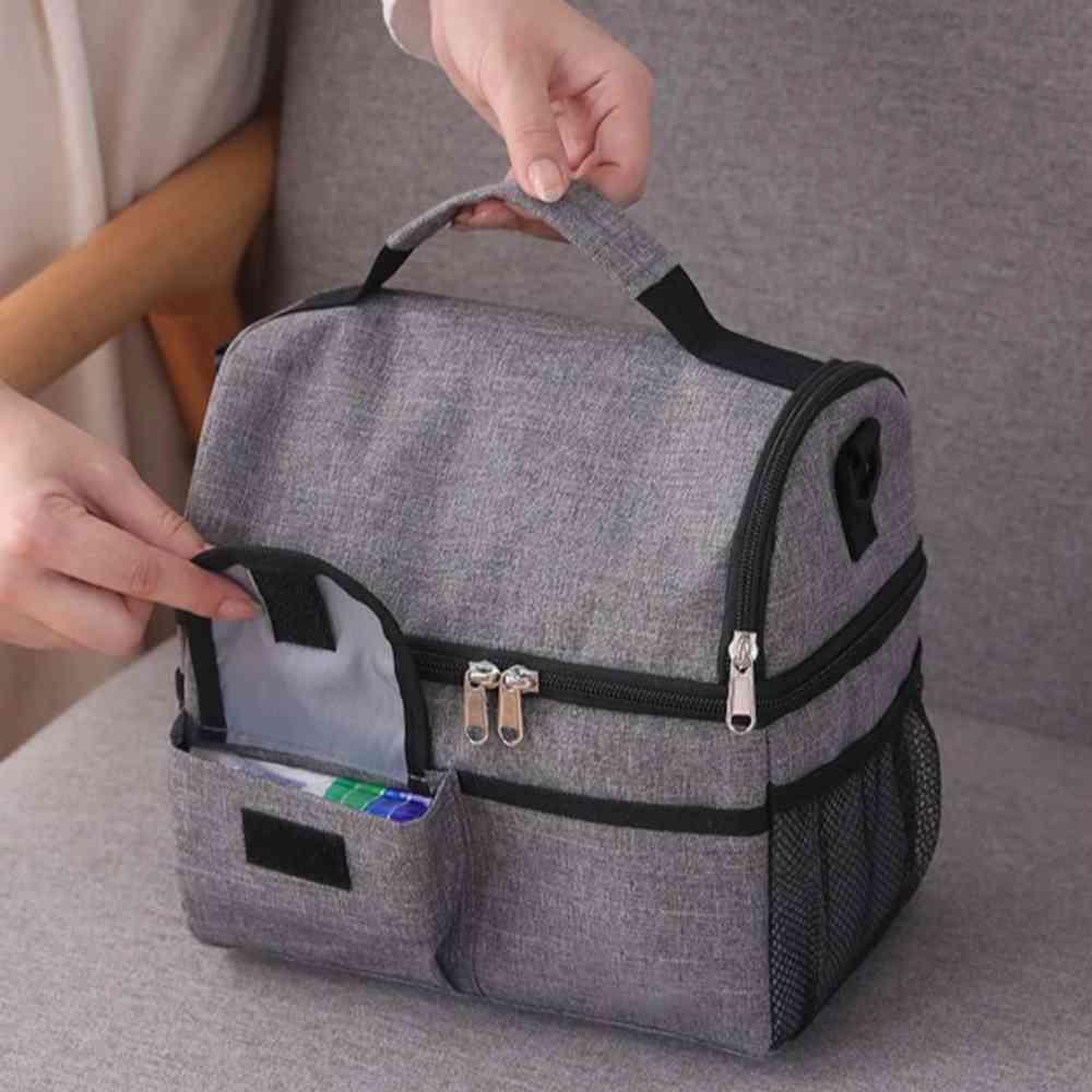 Bolsa Térmica Grande para Marmita com Duplo Compartimento 10L Urbanno cinza, com uma mão abrindo o bolso frontal para guardar talheres ou pequenos itens, destacando a organização acessível urbanno