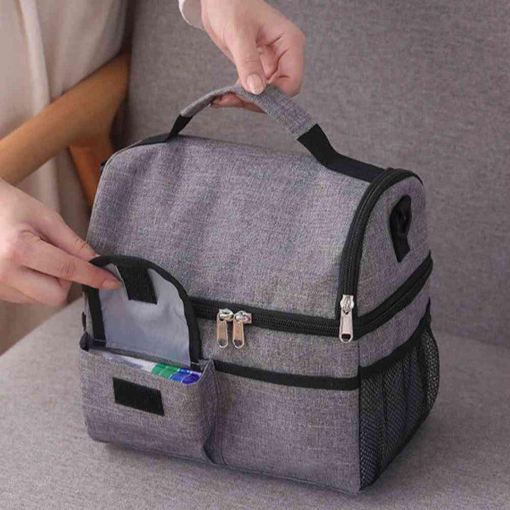 Bolsa Térmica Grande para Marmita com Duplo Compartimento 10L Urbanno cinza, com uma mão abrindo o bolso frontal para guardar talheres ou pequenos itens, destacando a organização acessível urbanno