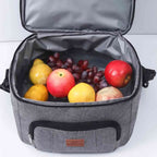 Bolsa Térmica Grande para Marmita com Duplo Compartimento 10L Urbanno cinza, aberta mostrando o compartimento superior cheio de frutas frescas como maçãs, uvas e peras, ideal para lanches saudáveis urbanno