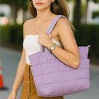 Mulher usando a Bolsa Tote de Academia e Dia a Dia Feminina Acolchoada Urbanno lilás no ombro, demonstrando estilo e praticidade em ambiente urbano