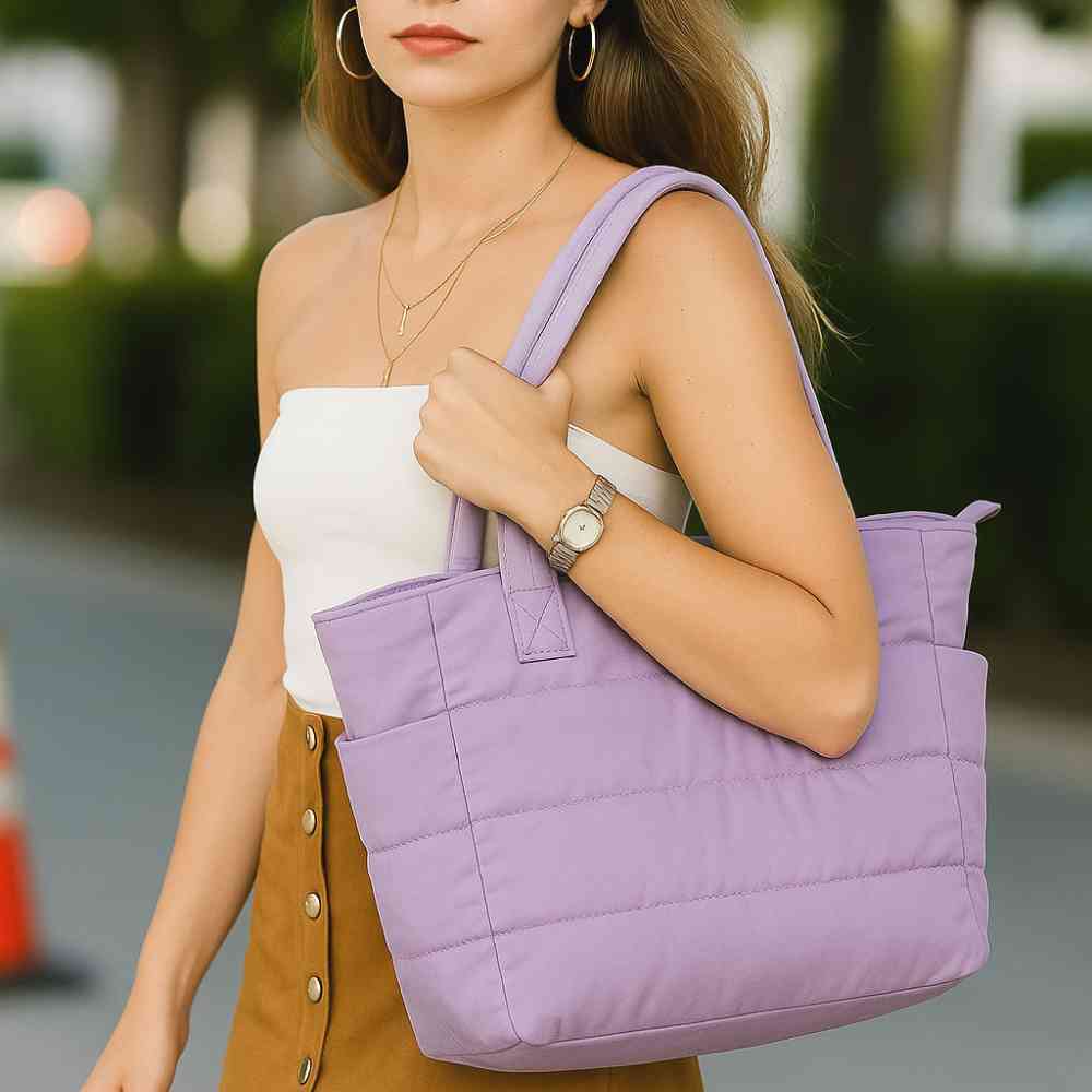 Mulher usando a Bolsa Tote de Academia e Dia a Dia Feminina Acolchoada Urbanno lilás no ombro, demonstrando estilo e praticidade em ambiente urbano