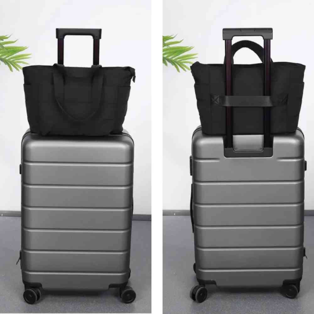 Bolsa Tote de Academia e Dia a Dia Feminina Acolchoada Urbanno preta, acoplada à alça de uma mala de viagem, vista frontal e traseira, demonstrando praticidade para viagens