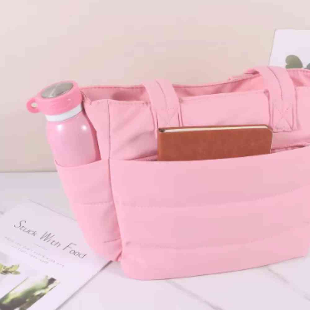 Bolsa Tote de Academia e Dia a Dia Feminina Acolchoada Urbanno rosa, mostrando bolsos externos com garrafa rosa e caderno, destacando organização