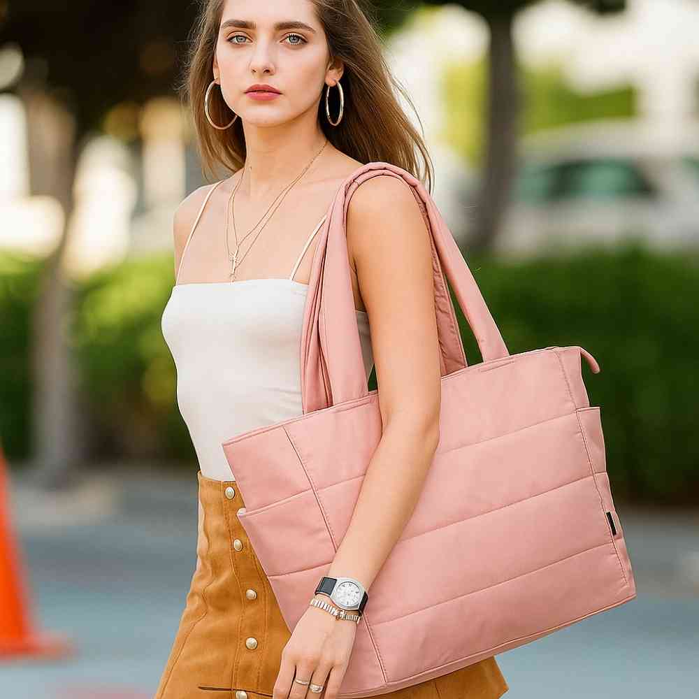 Mulher usando a Bolsa Tote de Academia e Dia a Dia Feminina Acolchoada Urbanno rosa no ombro, demonstrando estilo e praticidade em ambiente urbano