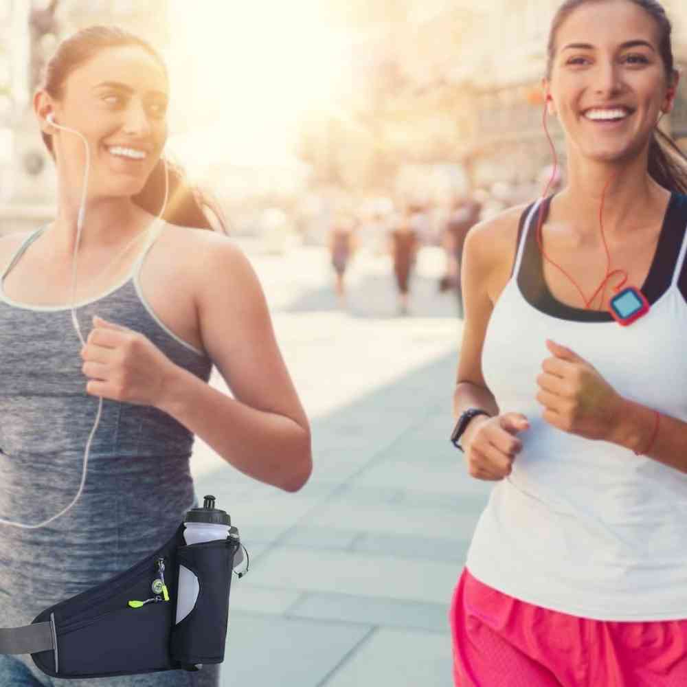 Duas mulheres correndo em ambiente urbano usando Cintos de Hidratação Pochete Shunmaii, uma com a preta e outra (parcialmente visível) com outra cor, ilustrando o uso prático durante a corrida urbanno