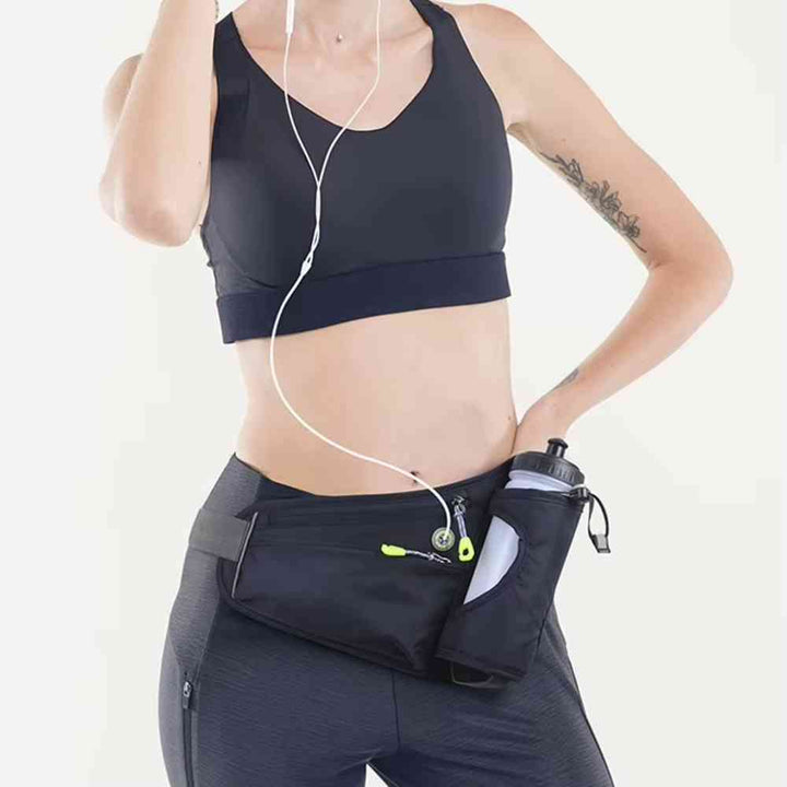 Mulher usando o Cinto de Hidratação Pochete para Corrida Shunmaii preta com garrafa, demonstrando ajuste confortável e acesso fácil para celular e itens durante exercícios urbanno