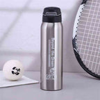 Garrafa de Academia Térmica com Canudo e Alça 500ml Urbanno prata, em ambiente esportivo com bola de tênis e raquete ao fundo, ideal para atletas urbanno