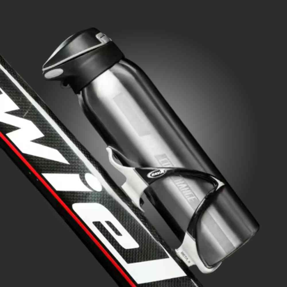 Garrafa de Academia Térmica com Canudo e Alça 500ml Urbanno prata, encaixada em suporte de garrafa em uma bicicleta de fibra de carbono, pronta para ciclismo de performance urbanno