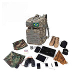 Mochila Exército Militar Tática 50L ACU (Digital Camo) Urbanno, com equipamentos como tablet, celular, binóculos, botas e roupas camufladas dispostos ao redor, demonstrando sua ampla capacidade para expedições e viagens.