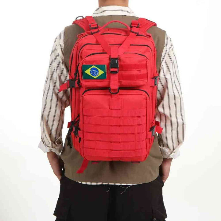 Mochila Exército Militar Tática 50L Vermelha Urbanno, sendo usada nas costas por uma pessoa com camisa listrada e colete, mostrando o ajuste e o design em uso.