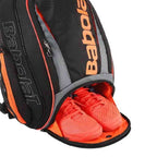 Imagem do compartimento separado para transportes de sapatos com o respiro da mochila raqueteira babolate preta com laranja da loja urbanno.