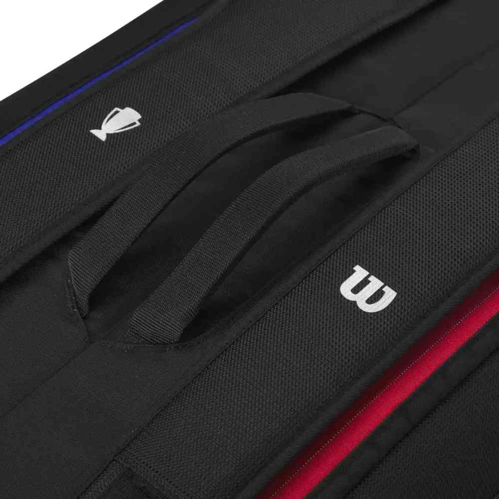 Detalhe da alça central da Mochila Raqueteira Wilson Tênis 9 Raquetes Térmica Preta Urbanno, com bordas coloridas em vermelho e azul e o logo Wilson em relevo.