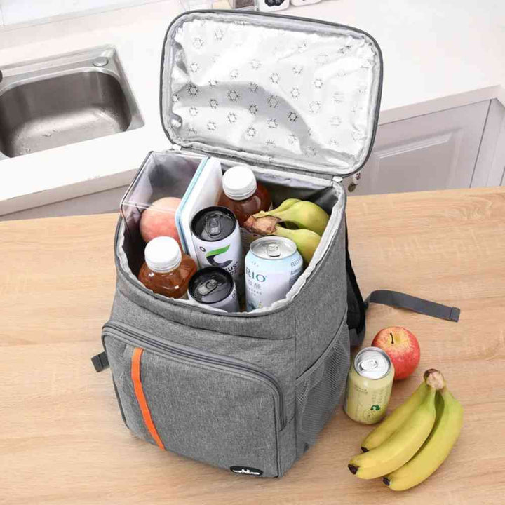 Mochila Térmica Cooler 18L Urbanno cinza aberta em bancada de cozinha, cheia de bebidas e frutas, demonstrando grande capacidade