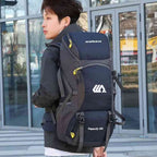 Homem jovem usando a Mochila de Viagem e Camping 50L Aventura Impermeável Urbanno azul nas costas, em ambiente urbano com prédios de vidro ao fundo, demonstrando o tamanho e como veste para aventuras urbanno