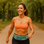 Pochete Cinto de Hidratação Multifuncional Impermeável para Corrida Azul Petróleo Urbanno, em uso por uma mulher sorrindo enquanto caminha em um parque, demonstrando o ajuste confortável e a praticidade para carregar pertences durante o exercício.