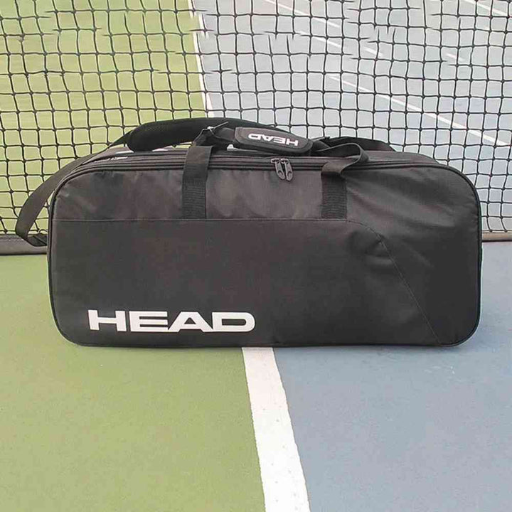 Raqueteira Head Tênis 6 Raquetes preta profissional Urbanno, sobre a quadra de tênis com a rede ao fundo, demonstrando o uso em ambiente esportivo